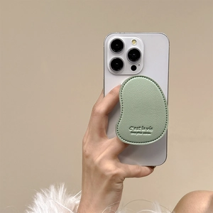 Close-up of mint green lychee leather mango shaped phone grip with C'est la vie engraving
