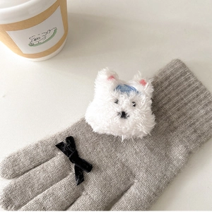 Close-up of grey knit glove featuring plush puppy head and black velvet bow detail