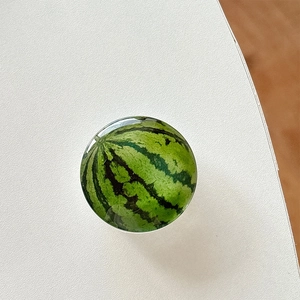Close-up of realistic 3D watermelon phone grip with smooth polished resin finish