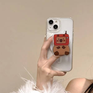 Detail of cute cartoon capybara phone grip with TV head on clear silicone case