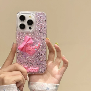 Sparkly pink iPhone case with 3D bow and Sweet lettering held by a person