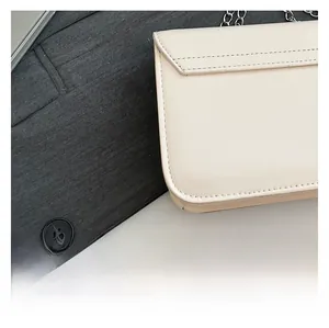 Close-up of beige chain crossbody bag showing high-quality stitching and silver metal link