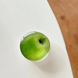 Close-up of green apple pattern phone grip with crystal clear resin finish