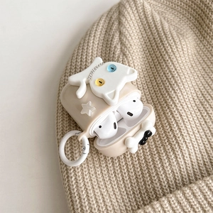Dettaglio custodia AirPods beige con gatto 3D su sfondo di berretto in maglia