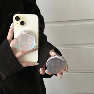 Macro detail of holographic fish-shaped magnetic phone grip on white smartphone case