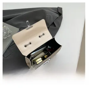 Interior view of beige chain crossbody bag showing capacity for phone and cosmetics