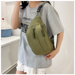 Detail of army green canvas chest bag with woven zipper puller and adjustable strap