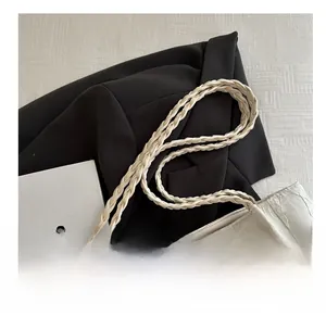 Close-up of cream silk tote with floral lace texture and braided handle detail