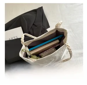 Internal view of a white embroidered tote bag showing large capacity for books and tablet