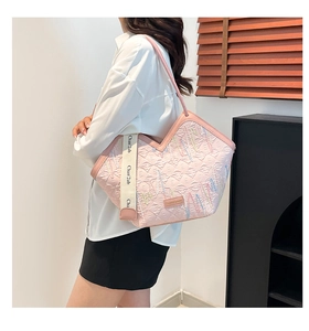 Detailed view of pink quilted tote bag with embroidered texture and wide logo strap