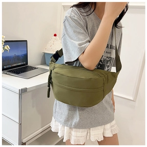 Detail of army green canvas crossbody chest bag with adjustable strap and braided zipper pull