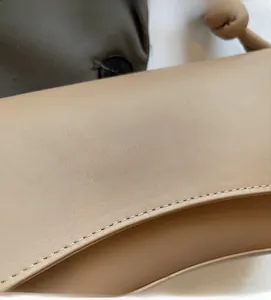 Detail of premium beige faux leather texture with elegant gold letter printing on bag