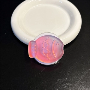 Close-up of a laser gradient fish-shaped magnetic phone grip with matte relief texture