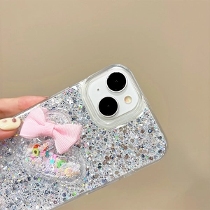 Detail of glitter iPhone case with pink fabric bow and heart-shaped shaker charm