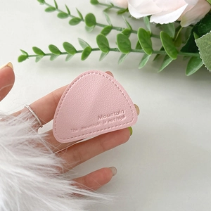 Macro detail of pink lychee leather phone stand with mountain pattern and debossed text