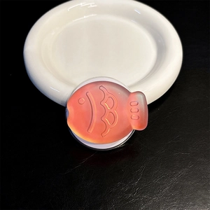 Detail of laser fish phone grip with orange gradient and frosted translucent texture