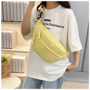 Detail of light yellow nylon crossbody bag with dual zipper and adjustable strap