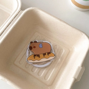 Detail showing cartoon capybara acrylic phone grip on white expandable airbag socket