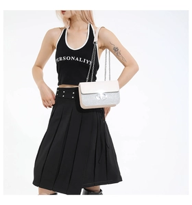 Detail of the chain strap and metal swivel lock on the sequined crossbody bag