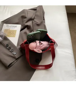 Detailed interior view of a red glossy shoulder bag showing capacity for phone and umbrella