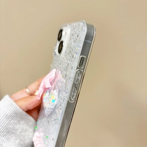 Detailed side view of glittery phone case with pink bow and 3D heart embellishments