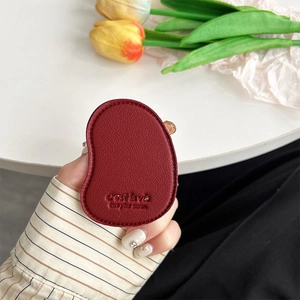 Close-up of dark red leather bean-shaped phone grip with embossed C'est la vie text