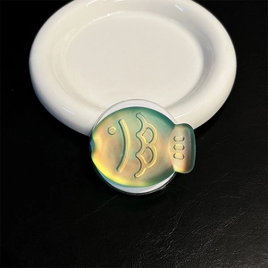 Macro detail of fish-shaped magnetic phone grip with yellow-green laser gradient finish