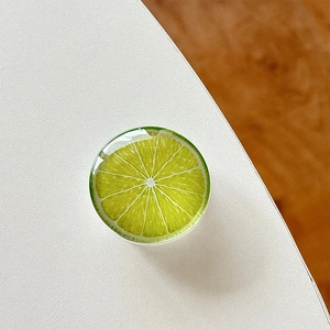 Macro detail of 3D lime slice phone grip with glossy epoxy resin finish on white surface