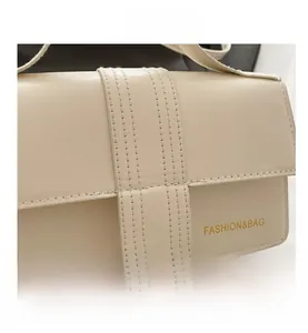 Dettaglio ravvicinato delle cuciture verticali e pelle PU su borsa a tracolla color crema