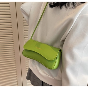 Green rectangular crossbody bag with FASHION & BAGS gold text on white sweatshirt