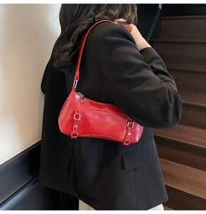 Detail of red glossy oil wax leather underarm bag with silver hardware and zipper