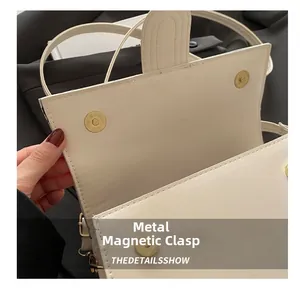 Dettaglio delle doppie chiusure magnetiche sulla borsa a mano in pelle color crema