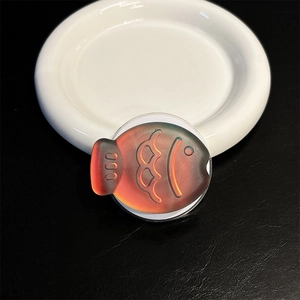 Detail showing laser gradient fish phone grip with embossed scales on white ceramic plate