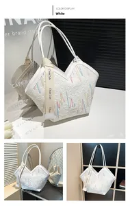Detail of white tote bag with diamond quilting and colorful wave embroidery pattern