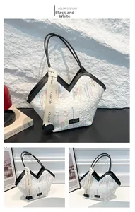 Detail of white quilted tote bag with multi-colored embroidery and branded wide strap