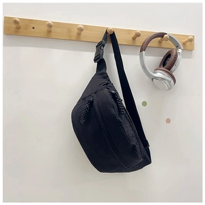 Detail of black canvas waist bag with adjustable buckle and water-resistant nylon fabric