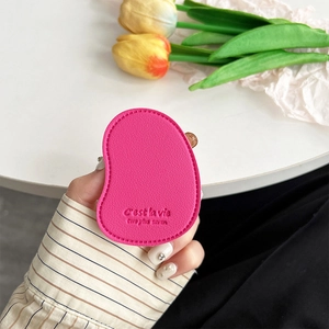 Detail of rose pink leather phone grip showing fine litchi texture and stamped quote