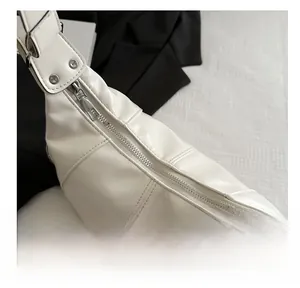 Close-up of smooth silver zipper and neat stitching on creamy white faux leather bag