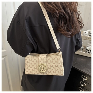 French vintage underarm bag with M monogram print and golden metal logo on the shoulder