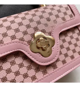 Macro view of pink monogram leather bag featuring a gold flower-shaped twist lock