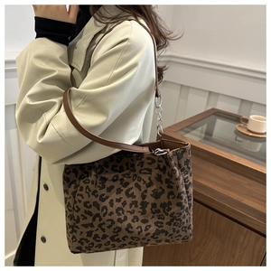 Detailed texture of leopard print corduroy tote bag with brown leather and silver chain strap