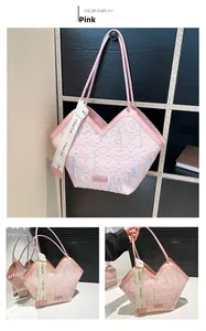 Detail view of pink quilted tote bag with heart wave embroidery and printed handles