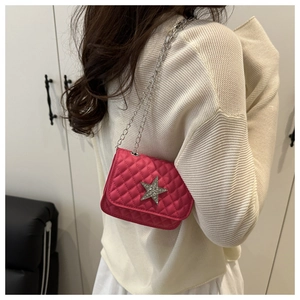 Detail of fuchsia quilted mini bag with crystal star and silver metal chain straps