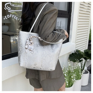 Detail of silver snake-pattern tote bag with printed silk scarf on the handle