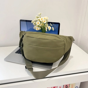Green minimalist nylon crossbody chest bag with adjustable strap and woven zipper pulls