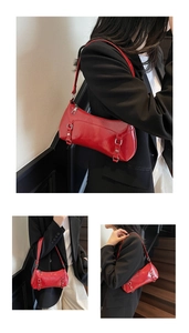 Close-up of red glossy leather underarm bag with silver buckles and mirror-like texture