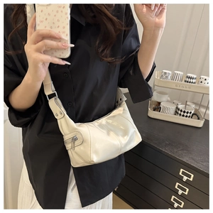 Detail of cream white faux leather shoulder bag with glossy finish and zipper pocket