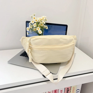Minimalist cream nylon crossbody chest bag with decorative woven rope zipper pull