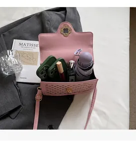 Internal view of light pink crossbody bag showing storage for phone, perfume and umbrella