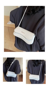 Detail of white minimalist underarm bag with wavy flap and gold embossed logo